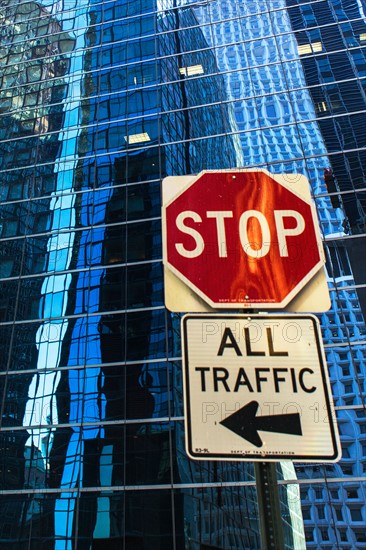 USA, New York, Distorted reflections in office building and stop sign in front