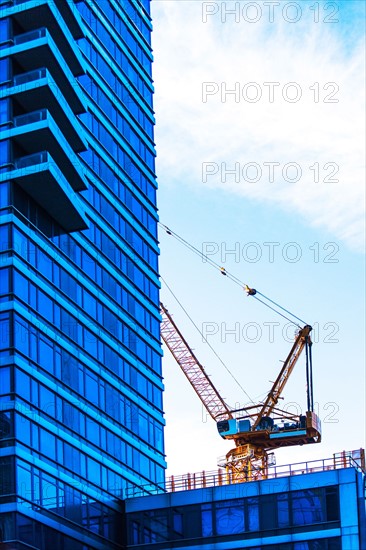 USA, New York, Crane by office building