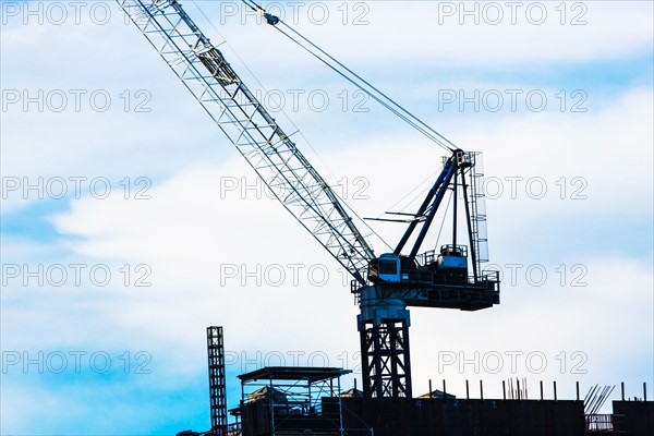 Crane at construction site against sky