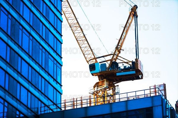 USA, New York, New York City, Crane with office building in foreground