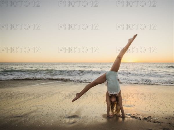 Girl (8-9) doing cartwheel on beach