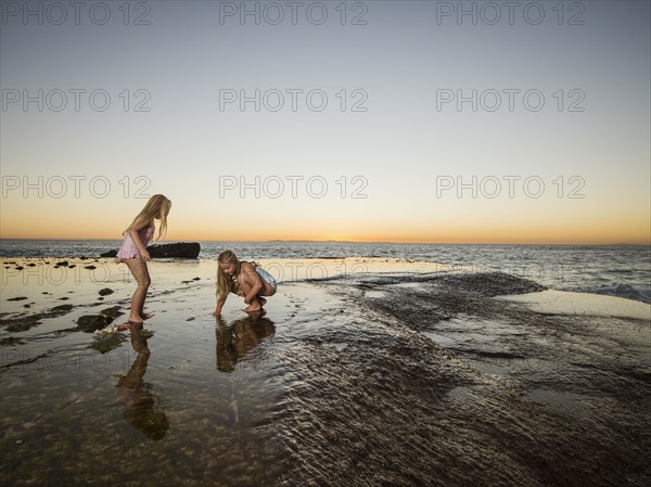 Girls (6-7,8-9) playing on beach