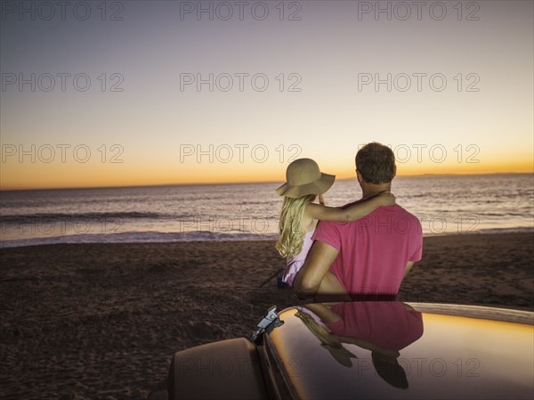 Father and daughter (4-5) looking at sea