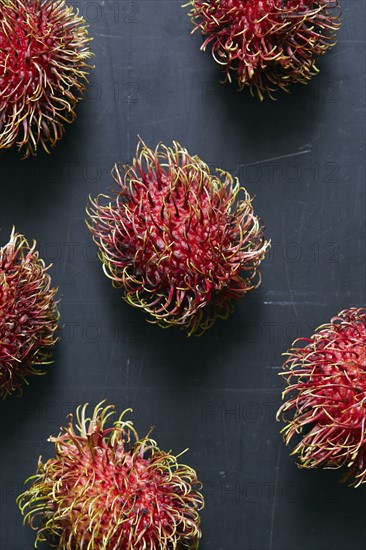 Rambutan (Nephelium lappaceum) fruits on grey surface