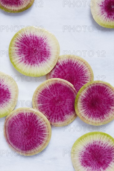 Slices of radish on white surface