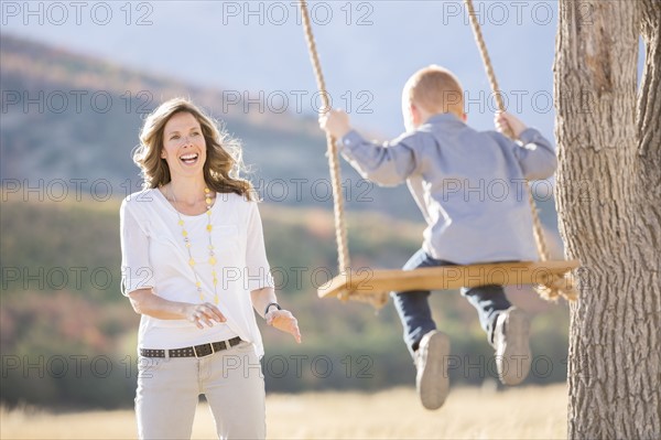 Mother with child (4-5) sitting on swing