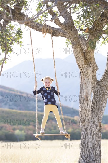 Girl (4-5) standing on swing