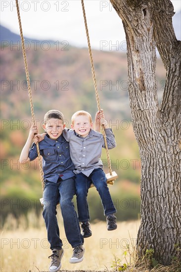 Two boys (4-5, 6-7) sitting on swing