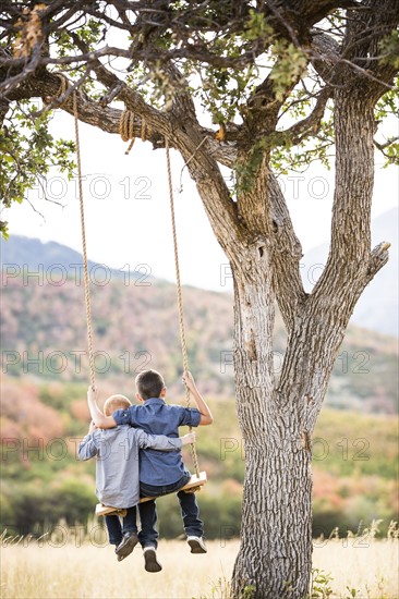 Two boys (4-5, 6-7) sitting on swing