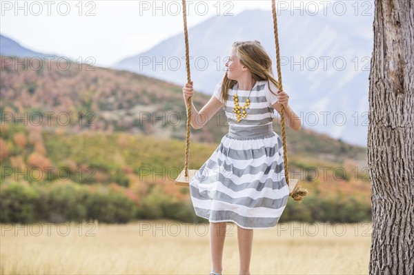 Girl (8-9) sitting on swing