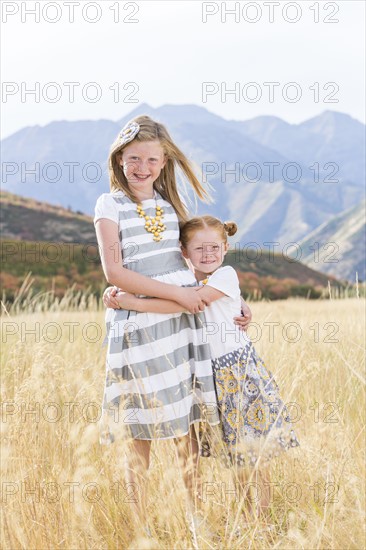 USA, Utah, Provo, Two girls (4-5, 8-9) standing in field