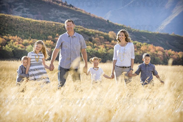 USA, Utah, Provo, Family with three children (4-5, 6-7, 8-9) standing in field