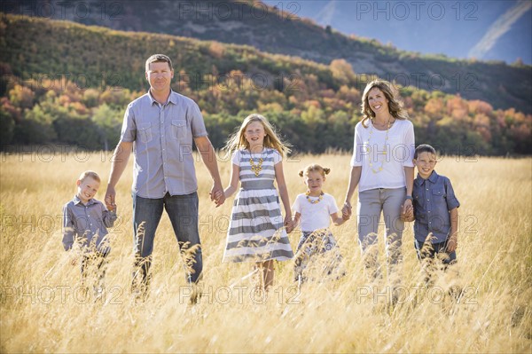 USA, Utah, Provo, Family with three children (4-5, 6-7, 8-9) standing in field