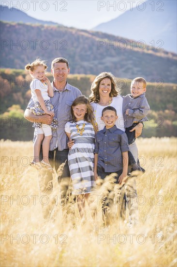 USA, Utah, Provo, Family with three children (4-5, 6-7, 8-9) standing in field