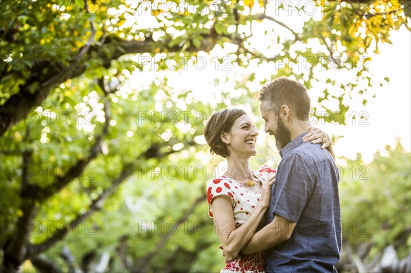 Couple embracing in cherry orchard