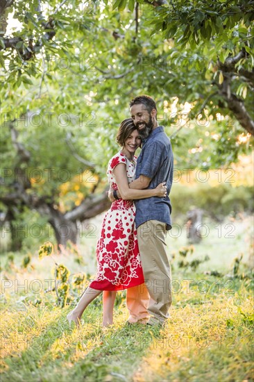 Couple embracing in cherry orchard