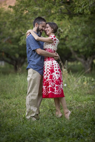 Couple embracing in cherry orchard