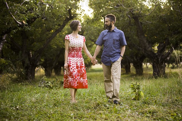 Coupleholding hands in cherry orchard