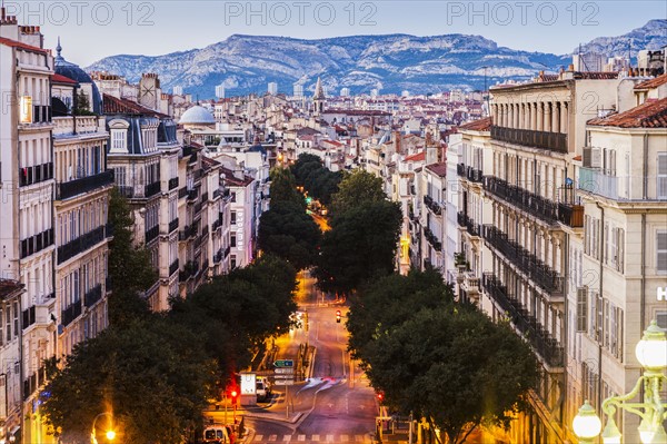 France, Provence-Alpes-Cote d'Azur, Marseille, Street in city, mountain in background