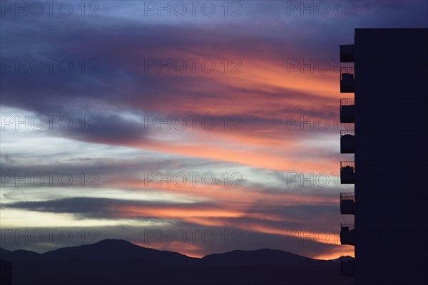 Silhouette of apartment building against colorful sky at sunset