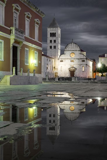 Croatia, Zadar, Buildings reflecting in puddle at dusk