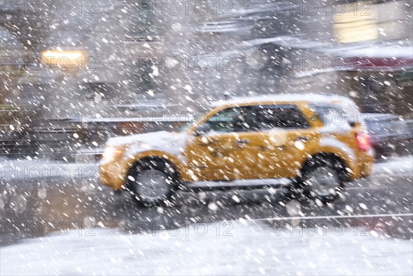 USA, New York State, New York City, Yellow cab driving during snowstorm.