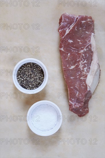 Raw rib eye steak on parchment paper