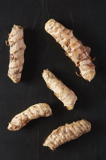 Turmeric roots on black background