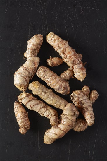 Turmeric roots on black background