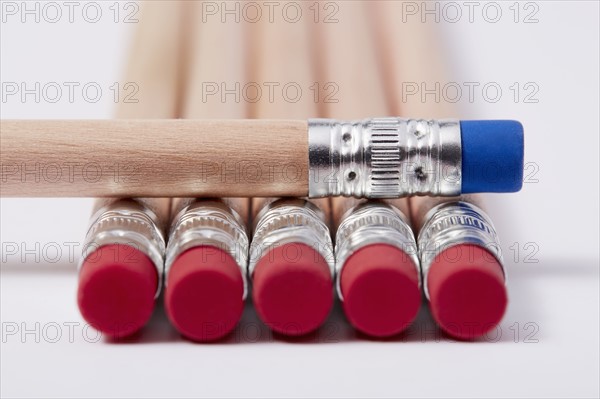 Wooden pencils with red erasers, one with blue on top