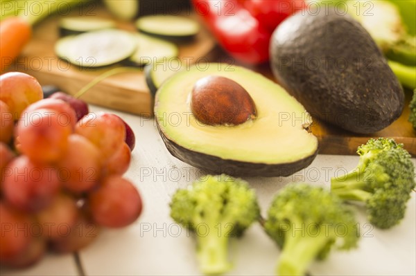 Avocado surrounded by various fruits and vegetables