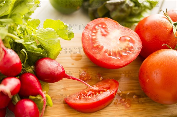 Tomato and radish on cutting board