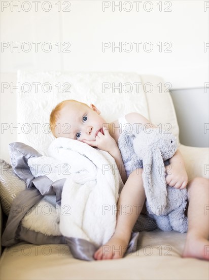 Baby boy (12-17 months) holding stuffed rabbit