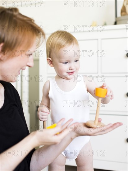 Mother playing with son (12-17 months) in nursery