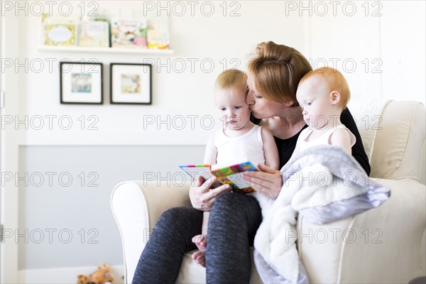 Mother and sons (12-17 months) reading picture book