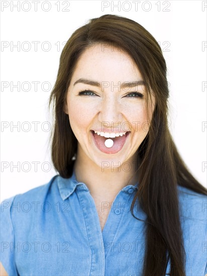 Woman showing mint on tongue