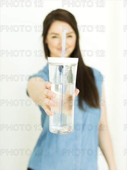 Woman wearing blue top holding drinking glass
