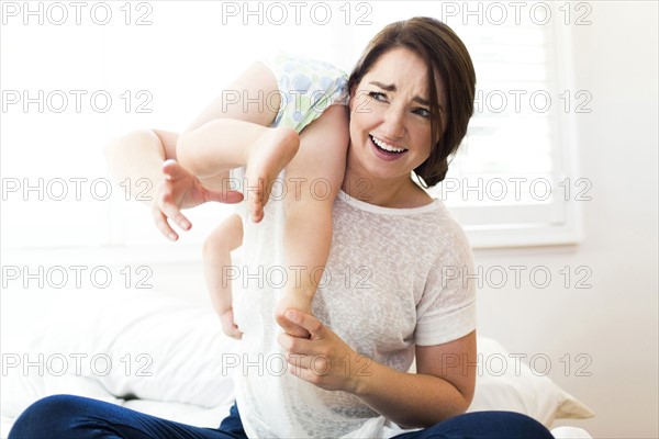 Mother playing with son (4-5) on bed