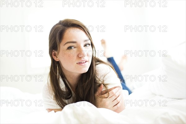 Portrait of woman lying on bed