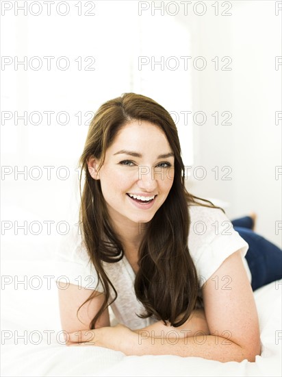 Portrait of woman lying on bed and smiling