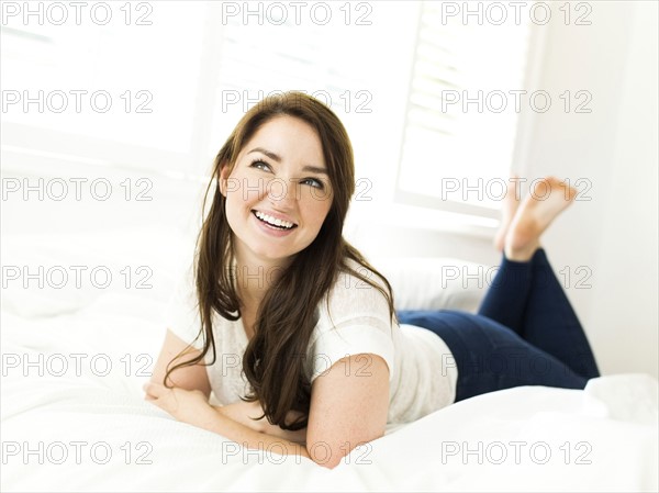 Portrait of woman lying on bed and smiling