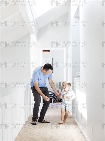 Father and son (4-5) playing in corridor