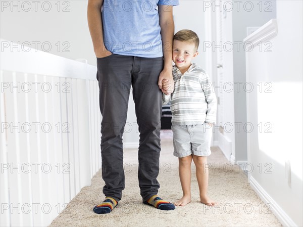 Father and son (4-5) standing in corridor