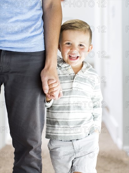 Father and son (4-5) standing in corridor