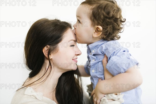 Son (4-5) kissing mother's forehead