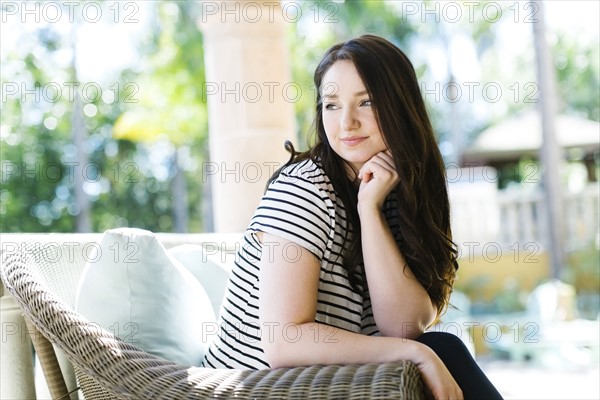 Woman resting on porch on sunny day