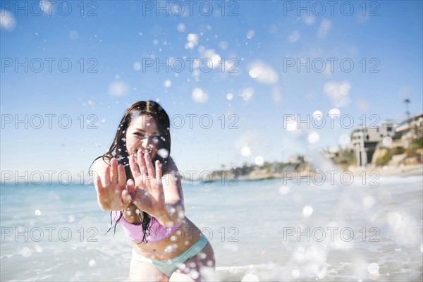 USA, California, Woman playing in water on Laguna Beach