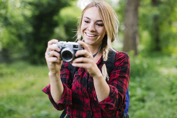 Young woman taking pictures in park