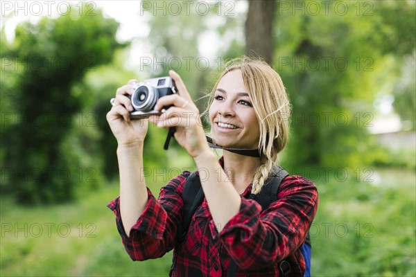 Young woman taking pictures in park