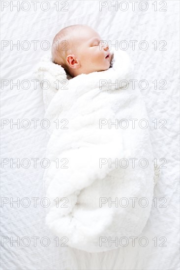 Baby boy (2-5 months) sleeping in white blanket